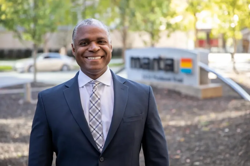 Former MARTA CEO Collie Greenwood standing in front of MARTA HQ with blurred MARTA sign visible in background.